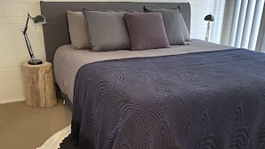 Une chambre à coucher avec un tapis en peau de vache, une couvre-lit à motifs et une tête de lit moderne.