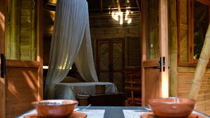 A room with a bed, a table with two bowls, and a window with a curtain. - Mint Cabin 1. Romantic Ecolodge in the jungle by the sea (San Pancho)