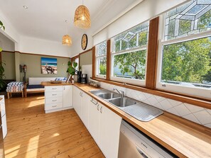 Une cuisine moderne avec des plans de travail en bois, des armoires blanches et un lave-vaisselle Bosch.