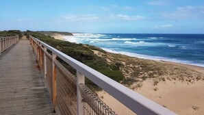 Una pasarela de madera que conduce a una playa con vistas al océano.