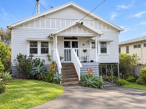 A single-story house with a front porch, a set of stairs leading to the entrance, and a well-maintained lawn.