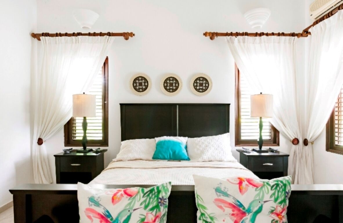 A bedroom with a bed, nightstands, and decorative wall art.