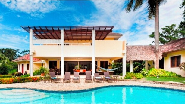 Un bâtiment à deux étages avec une piscine à l’avant.