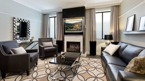 A modern living room with a fireplace, leather sofas, a coffee table, and a large mirror. - Family Retreat In Top Blue Mountains Location (Katoomba)