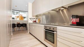 A modern kitchen with stainless steel appliances, a built-in oven, and a coffee machine.