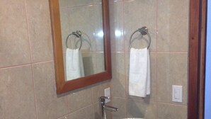 Ein Badezimmer mit Waschbecken, Spiegel und Handtuchhalter.