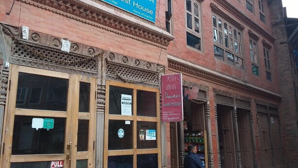 A traditional building with a sign for 'Mountain Guest House' indicating it is located at Durbar Square, Bhaktapur, Nepal.