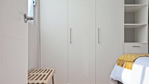 A bedroom with a bed, wooden bench, wardrobe, and a small table. - Located In One Of The Oldest Streets Of The Historic Center Of Coyoacan (México D.F.)