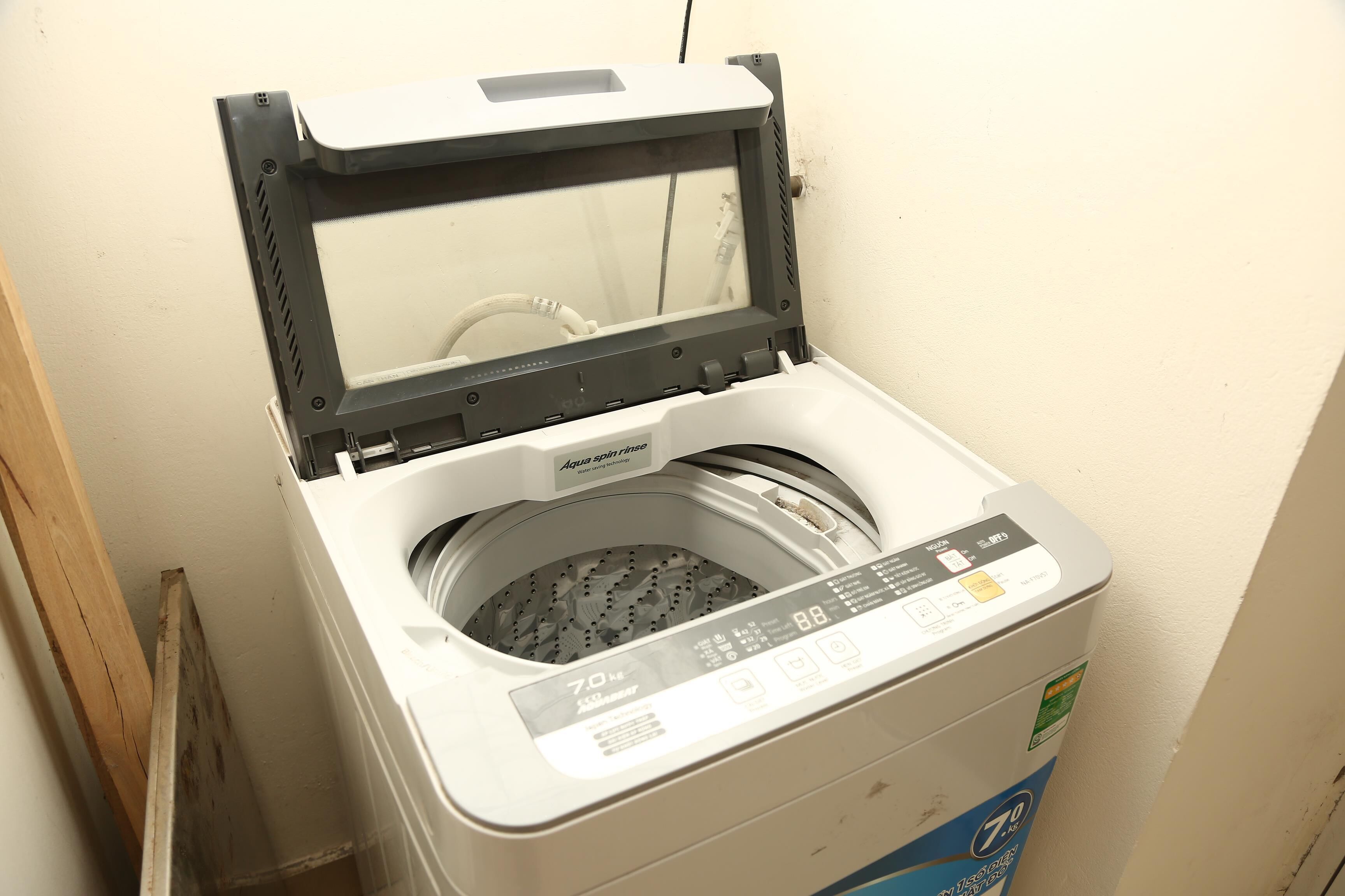 A front-loading washing machine with a digital display, a control panel, and a transparent door.