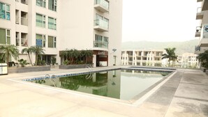A swimming pool with a clear blue edge, surrounded by a tiled deck.