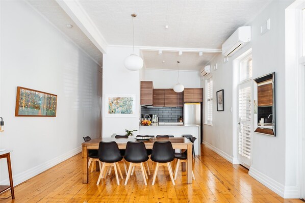 A modern kitchen with wooden cabinets, a dining table with black chairs, and pendant lighting. - ERIN RESIDENCE ON RICHMOND HILL - WiFi, NETFLIX, PARKING (Richmond)