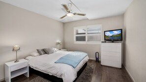 A bedroom with a bed, nightstand, lamp, TV, and a ceiling fan. - Moana 4 - Great Position (Avoca Beach)