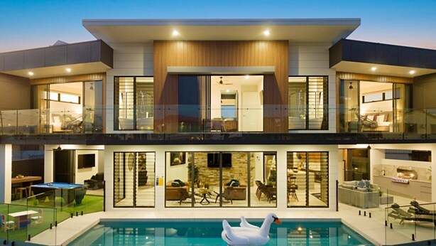 A modern two-story house with a swimming pool and a swan float.