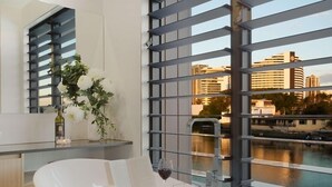 A modern room with a large window overlooking a river and cityscape.