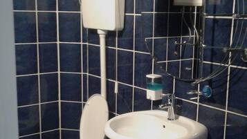 Une salle de bain équipée de toilettes, d’un lavabo et d’un bidet.