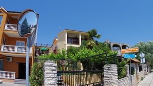 Un hôtel doté d’un balcon, une enseigne indiquant « Boutique Hotel Oasi », et un panneau de signalisation indiquant « Restaurant ».