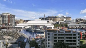 En stadsbild vid vattnet med en framträdande vit kupolbyggnad, en stor byggnad med ett välvt tak och en modern byggnad med en slät fasad.