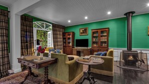 Un salon chaleureux avec des murs verts, une cheminée et des meubles en bois.