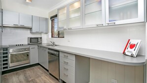 Eine moderne Küche mit grauen Schränken, einer Mikrowelle, einem Backofen und einem Geschirrspüler.