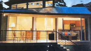 Una casa moderna con un amplio ventanal, una escalera y un comedor.