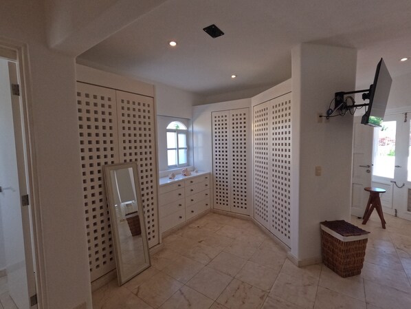 A spacious room with a large window, a mirror, and a small table.