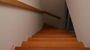 A wooden staircase with a handrail, leading to a landing. - Duplex apartment. One block from the Stone Cathedral. (Canela)