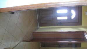 Ein Badezimmer mit einem Holzbadezimmerschrank, einem Spiegel und gefliesten Wänden.