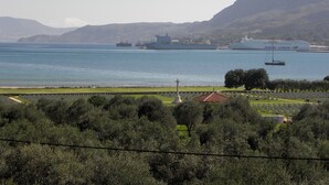 Eine Küstenlandschaft mit einem Friedhof, einem großen Schiff und einer Segelyacht.