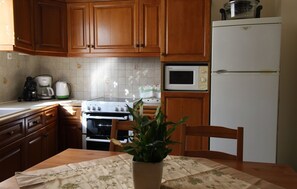 Kitchen area with a stove, refrigerator, and microwave, perfect for preparing meals.