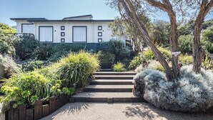 Una casa moderna con vialetto lastricato che conduce a una scalinata.