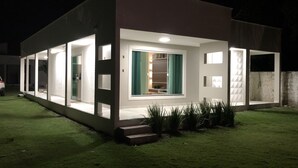 Uma casa moderna com grandes janelas e interior bem iluminado.