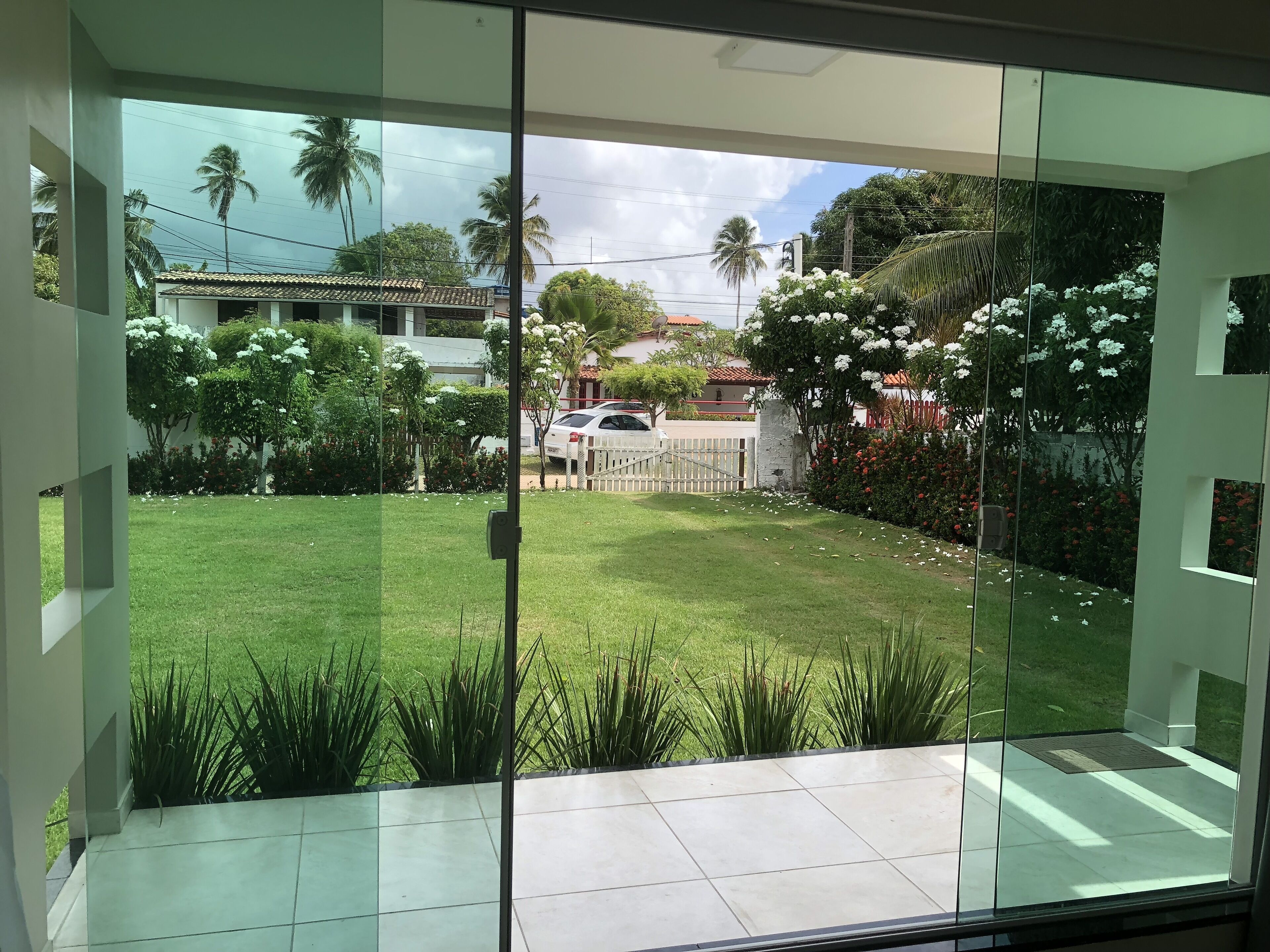 A modern interior with large glass doors leading to a well-maintained outdoor garden.