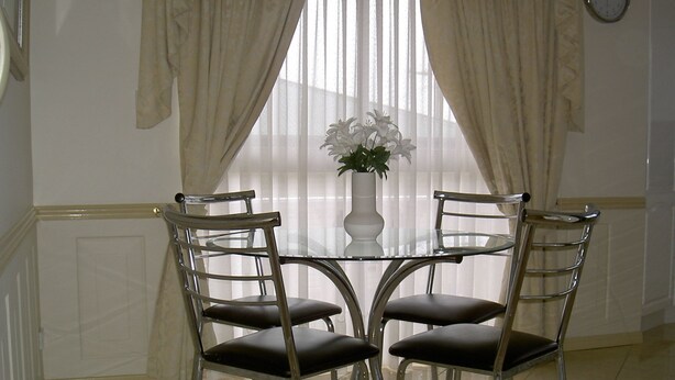 A dining area with a round glass table and four metal chairs with cushioned seats. - "Redcliffe Villa" - Redcliffe Q 4020 (Redcliffe)