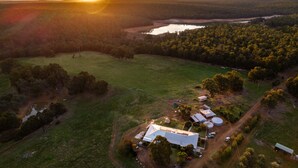 An aerial view of a rural property with a large house, several outbuildings, and a surrounding landscape including fields and a body of water. - Charming Rural Escape in Mumballup - Views, Fire Pit, Walks & Pet-Friendly Stay (Mumballup)
