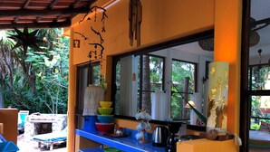 A kitchen with blue countertops, a large window, and various kitchen items.