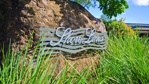 A large rock with a metal sign that reads "Shoreline." - Shorelines 26, Seaview Apartment on Hamilton Island (Hamilton Island)