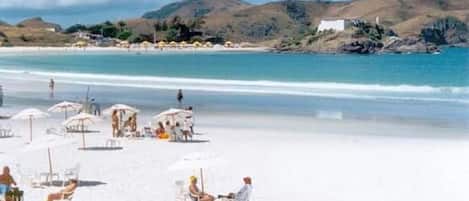 A beach with umbrellas and sun loungers.