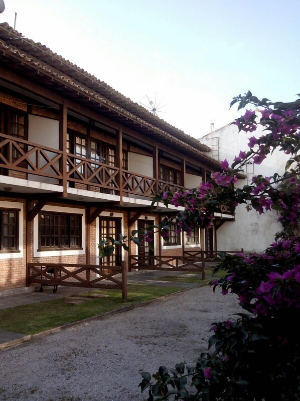 A traditional building with a wooden balcony and a gravel courtyard. - EXCELLENT 3-BEDROOM HOUSE IN A GATED COMMUNITY ON THE BEACH (Cabo Frio)