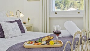 A neatly made bed with a tray of food and wine, a lamp, and a window with a view of trees. - CygnetOldBank- Accommodation, Cafe Escape the everyday, style & bliss (Cygnet)