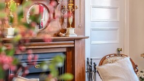 A room with a fireplace, a mirror, and a bed with a headboard. - CygnetOldBank- Accommodation, Cafe Escape the everyday, style & bliss (Cygnet)