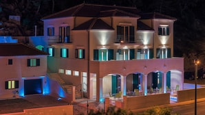 Een meerlaags huis met een balkon, een garage en een goed verlichte ingang.