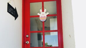 Eine rote Tür mit Fensterteil und Hasendekoration.