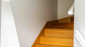 Un escalier en bois avec une rampe blanche.