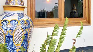Una ventana con vista al atardecer, una maceta decorativa de cerámica y un letrero que dice "Casa Grande".