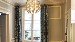 A room with a white table, a chair, a patterned curtain, and a chandelier. - Brand new chic 30 m2 for 4, quite, in the best part of the hypest 9th district (Paris)