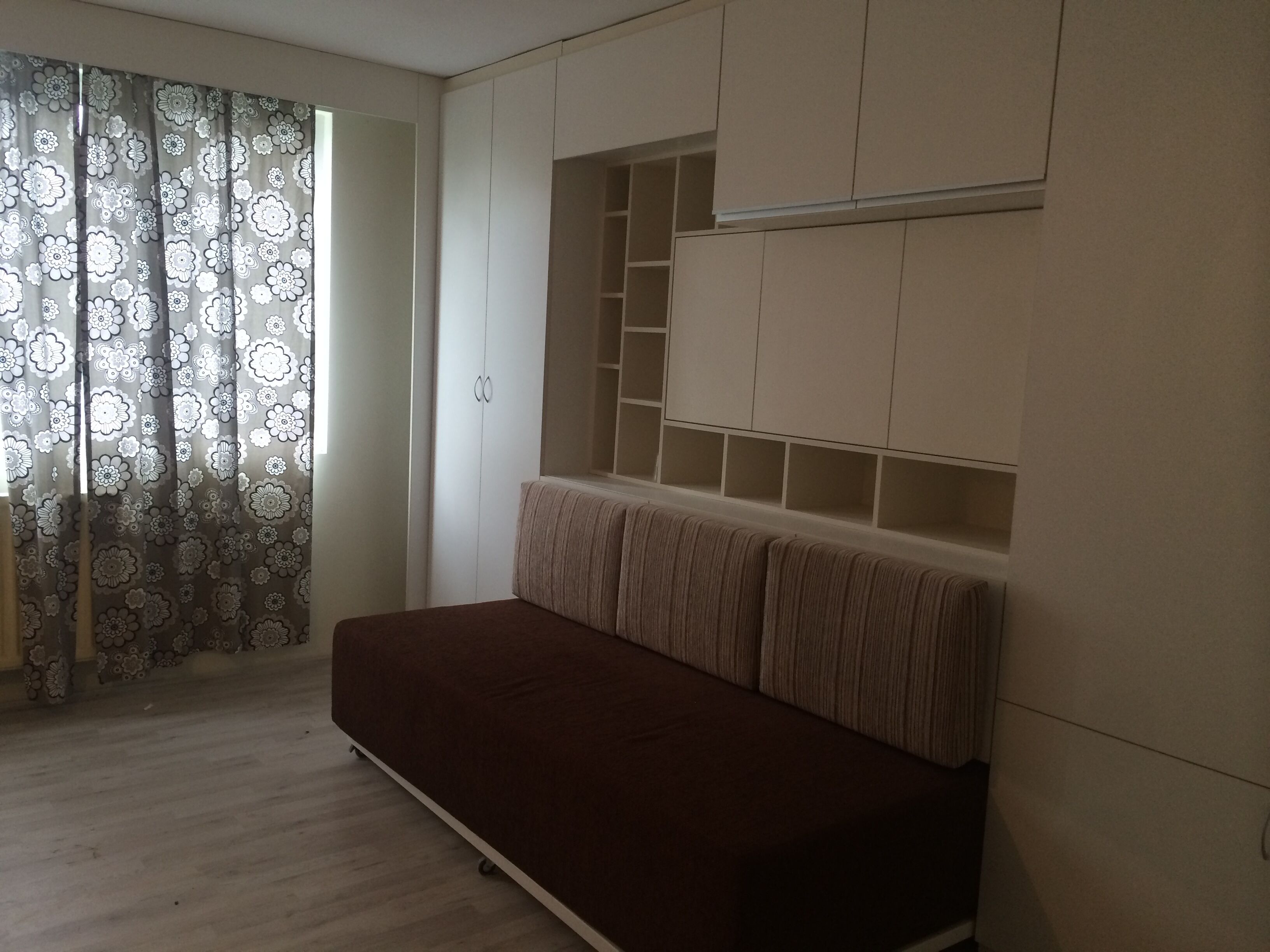 The bed has been rolled in to make a couch.