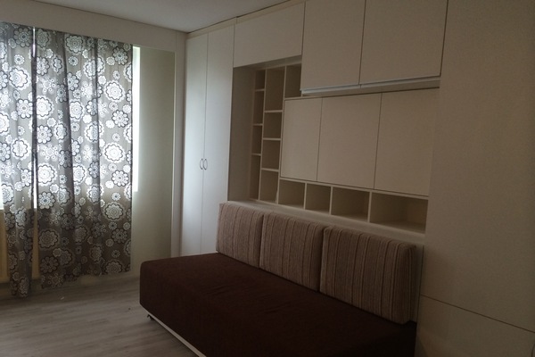 The bed has been rolled in to make a couch.