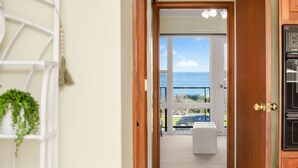 A doorway leading to a balcony with a view of the sea. - Beautiful Beach Front Townhouse (Victor Harbor)