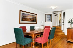 Guests can dine in comfort with a spacious table and six chairs, surrounded by framed artwork and a wooden cabinet.