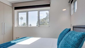 A bedroom with a bed, a window, and a wardrobe.